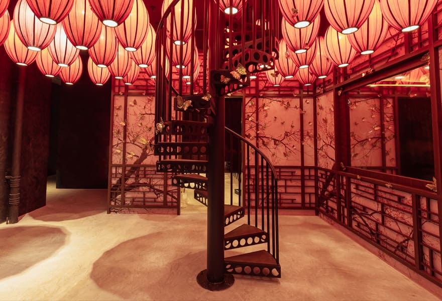 Interior space with red lantern ceiling, spiral staircase, and decorative wall panels