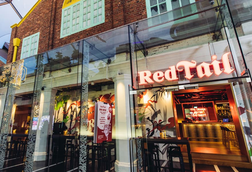 Exterior view of RedTail bar with glass entrance and illuminated signage